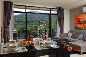 a living room with a couch and a table with food at Nai Harn Condominium in Nai Harn Beach