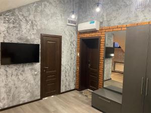 a room with a tv on a wall with a mirror at Апарт-отель Attic in Zabaykal'sk