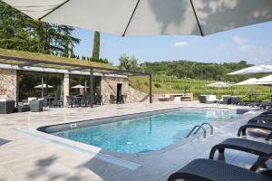 basen z krzesłami i parasolami w obiekcie Il Roncal Wine Resort - for Wine Lovers w mieście Cividale del Friuli