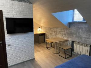 Una habitación con una mesa y un televisor en una pared. en Апарт-отель Attic, en Zabaykal'sk