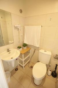 ein weißes Badezimmer mit Toilette und Waschbecken in der Unterkunft A2J Executive Studio Suite near Skyranch & Malls Tagaytay in Tagaytay