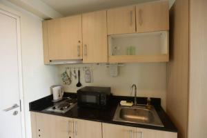 eine kleine Küche mit Spüle und Mikrowelle in der Unterkunft A2J Executive Studio Suite near Skyranch & Malls Tagaytay in Tagaytay