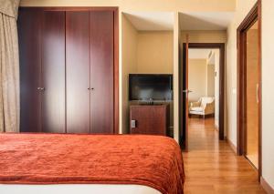 a hotel room with a bed and a television at Ilunion Málaga in Málaga