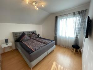 a bedroom with a bed and a large window at Ferienwohnung Bellissima in Ering