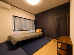 a bedroom with a bed with a window and a table at Guest House Suzumeno Kakurembo in Koyasan