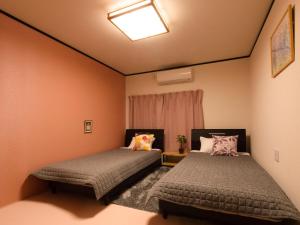 Postel nebo postele na pokoji v ubytování Guest House Suzumeno Kakurembo