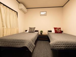 Postel nebo postele na pokoji v ubytování Guest House Suzumeno Kakurembo