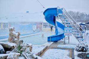 a blue and yellow park bench in the snow at Aqua Vita Thermal SPA in Mostovskoy