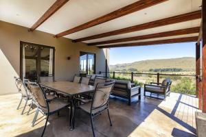 a dining room with a table and chairs on a patio at Walkersons Estate Red Oak Ridge in Dullstroom