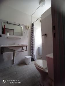 La salle de bains blanche est pourvue de toilettes et d'un lavabo. dans l'établissement hotel l'échappée d'oléron, à Saint-Georges-dʼOléron