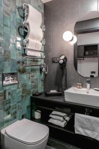 a bathroom with a toilet and a sink and a mirror at Loop Hotel Vilnius in Vilnius