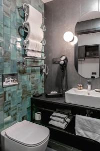 a bathroom with a toilet a sink and a mirror at Loop Hotel Vilnius in Vilnius