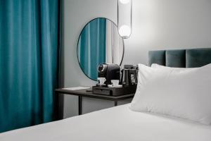 a bedroom with a bed and a mirror at Loop Hotel Vilnius in Vilnius