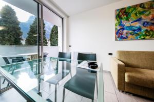 a living room with a glass table and a chair at Apartments Garda Lake in Riva del Garda