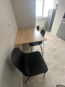 a table and chairs in a room with a kitchen at Свежая и красивая квартира! in Cherkasy