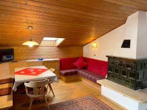 ein Wohnzimmer mit einem roten Sofa und einem Tisch in der Unterkunft Residence Lastei in St. Ulrich in Gröden