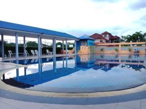 a pool at a resort with tables and chairs at Pattaya Bed Boutique SHA in Nong Prue
