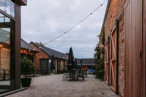 a patio with tables and chairs and a string of lights at Oud Gemeentehuis in Poelkapelle