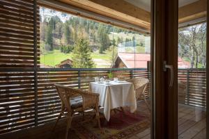 a table and chairs on a balcony with a view at Ferienwohnungen am Walmendingerhorn in Mittelberg