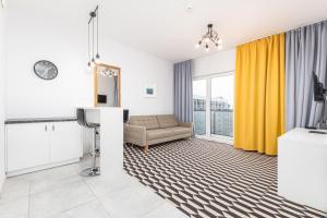 a living room with yellow curtains and a couch at Prymasa Tysiąclecia 83A (D) by Homeprime in Warsaw
