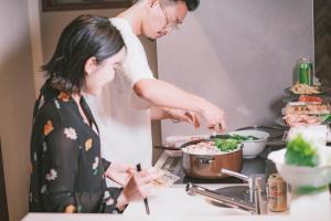 Un hombre y una mujer preparando comida en una cocina. en GRAND BASE Hakata Bay, en Fukuoka