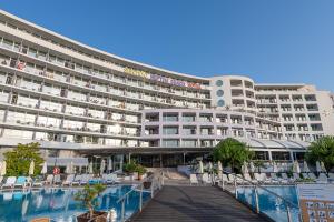 a large building with a swimming pool in front of it at Hotel Neptun Beach in Sunny Beach