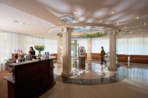 a lobby with people sitting at a reception desk at Lecco Hotel in Mytishchi