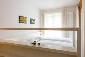 Biała sypialnia z 2 pingwinami siedzącymi na łóżku w obiekcie Ferienwohnungen am Walmendingerhorn w mieście Mittelberg