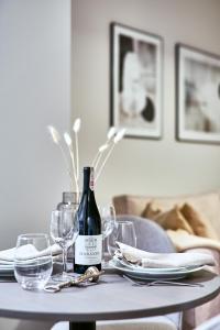 a table with a bottle of wine and glasses on it at LAGUNA Apartament Polanica Residence 35 in Polanica-Zdrój