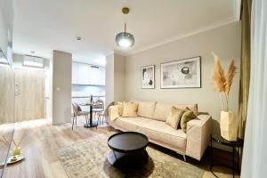 a living room with a couch and a table at LAGUNA Apartament Polanica Residence 35 in Polanica-Zdrój