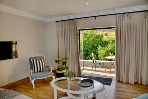 a living room with a glass table and a sliding glass door at Thanda Manzi Country Hotel in Centurion