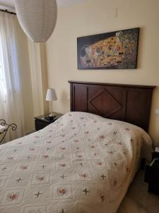una camera da letto con un letto con una trapunta sopra di Vistamar Estepona a Estepona