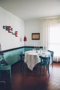 una sala da pranzo con tavolo e sedie bianchi di Chez Marie a Linguizzetta
