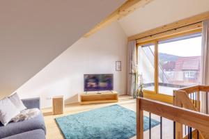 ein Wohnzimmer mit einem Sofa und einem TV in der Unterkunft Apartments Bären in Elzach