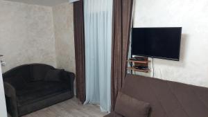a living room with a couch and a flat screen tv at Apartments Vila Djurdja in Kopaonik