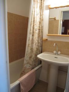 a bathroom with a sink and a shower curtain at Boost Your Immo Comète Réallon 109c in Réallon