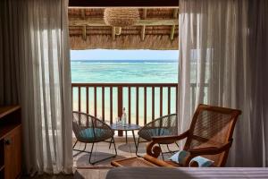 a room with a balcony with a view of the ocean at C Mauritius in Belle Mare