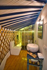 a bathroom with a sink and a toilet in a room at Glamping El Jardín De Las Delizias Valle Del Jerte in Casas del Castañar