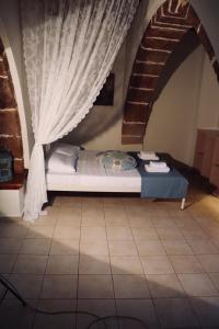 1 dormitorio con 1 cama con cortina y escalera en The Old House Cottage en Malia