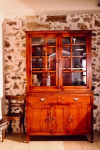 a wooden cabinet with glass doors in a room at The Old House Cottage in Malia