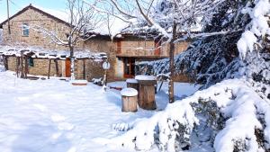 a house in the snow with two logs at Cascina Boschetto in Saliceto