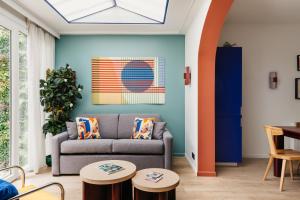 a living room with a couch and two tables at Edgar Suites Auteuil - Le Marois in Paris