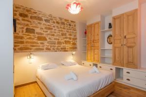 - une chambre avec un lit et un mur en briques dans l'établissement DIFY Chardonnay - Bellecour, à Lyon