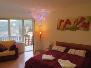 a bedroom with a bed and a chandelier at Panoramic Apartment 301 in Eagle Rock Complex in Beli Iskar