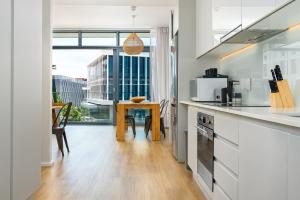 a kitchen with white counters and a table and a window at The Axis Luxury Apartments in Cape Town