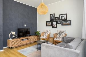 een woonkamer met een bank en een tv bij The Axis Luxury Apartments in Kaapstad