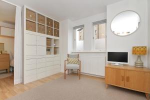 a living room with a tv and a desk with a chair at City Centre Haven Apartments in Edinburgh