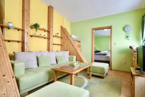 a living room with a green couch and a table at Hills View Apartment in Donovaly