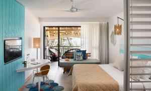a bedroom with a bed and a desk and a room at C Mauritius in Belle Mare