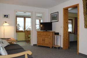 een woonkamer met een bank en een tv op een kast bij Haus & Heim Ferienwohnung in Oberstdorf